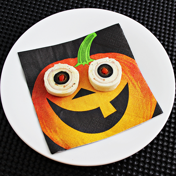 Here's an easy Halloween party foods idea: Eyeball Pinwheels! They give the creepy look of bloodshot eyeballs and are especially fun when served on jack-o-lantern napkins.