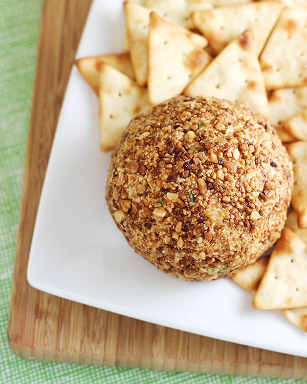 This Pina Colada Cheese Ball recipe is a party food that is sure to be a favorite! Features toasted macadamia nuts, cream cheese, pineapple, green onions, and sweetened flake coconut.