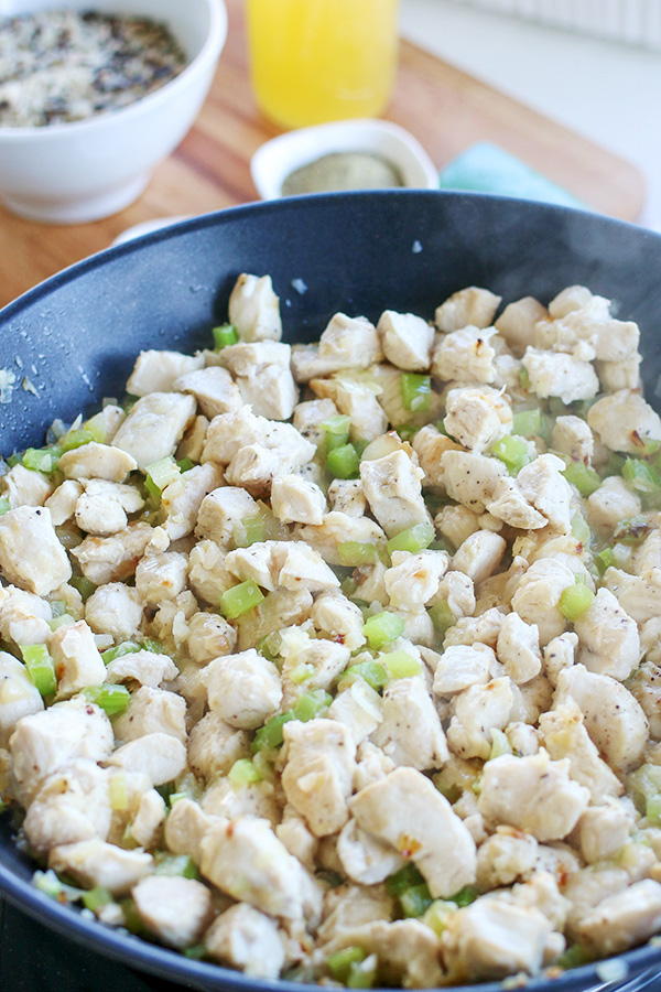 Seasoned chicken with celery and onion in a skillet