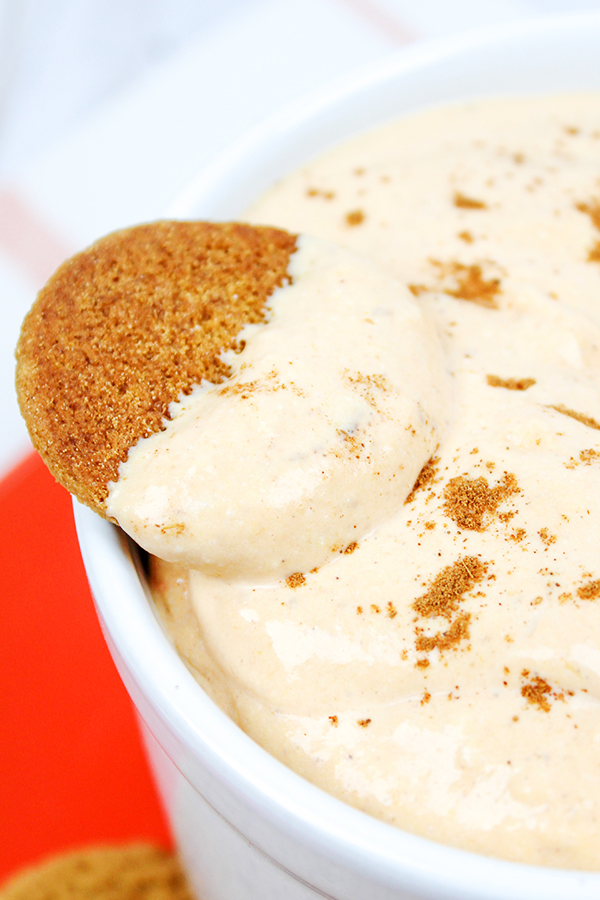 Easy Pumpkin Dessert Dip, served in a bowl surrounded by a plate of gingersnap cookies for dipping.