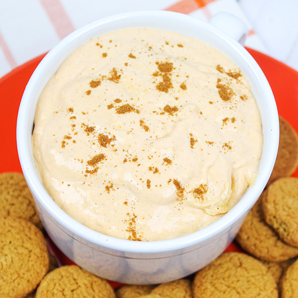 Bowl of pumpkin dip surrounded by gingersnap cookies.