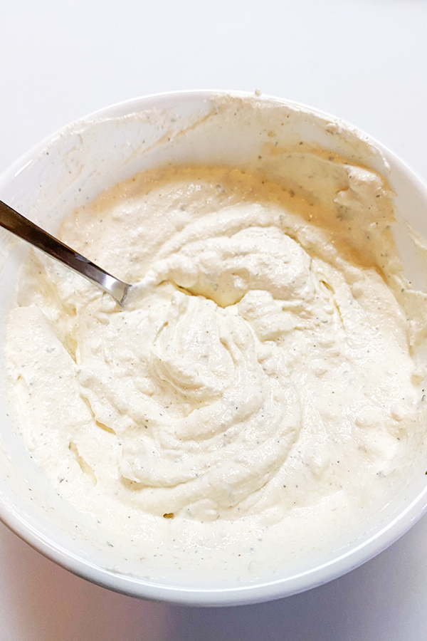 Homemade onion dip, made with sour cream, in a white bowl