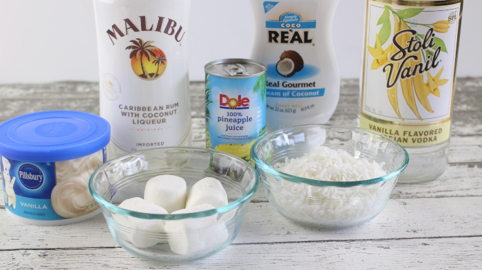 The ingredients to make Mini Bunny Tail Cocktails. Coconut Rum, Pineapple Juice, Cream of Coconut, Vanilla Vodka, Vanilla Frosting, Marshmallows, and Shredded Sweetened Coconut