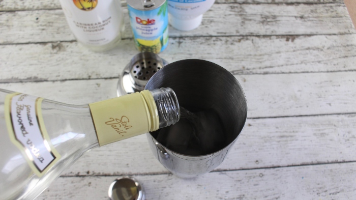 Vanilla Vodka is poured into a metal shaker.