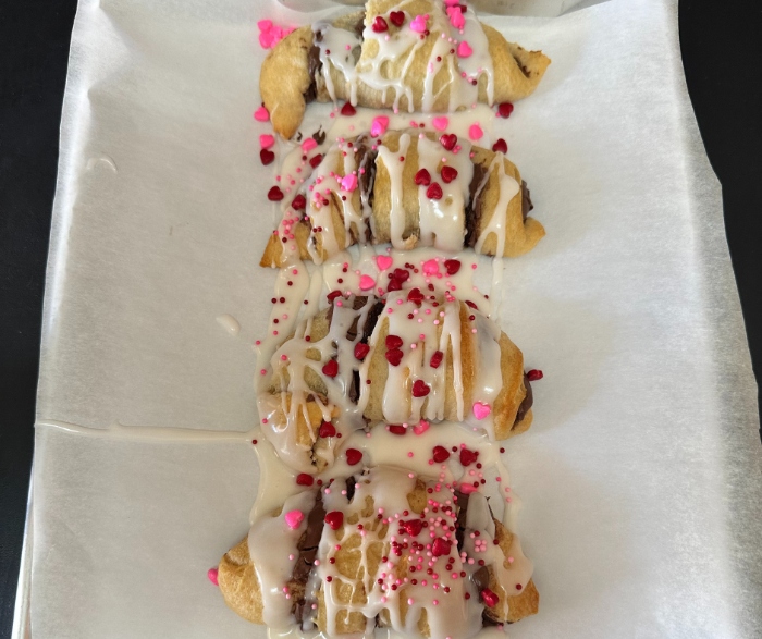 After cooking the the nutella crescents, you drizzle the icing on top of them and add the Valentine's Day sprinkles.