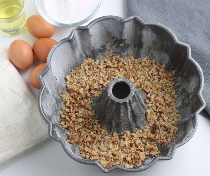 Before you put in the cake filling, add the chopped walnuts to the bottom of your floured cake pan.