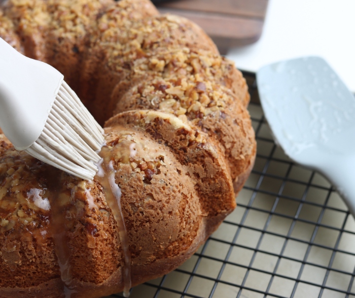 After you make the hot rum glaze, use a pastry brush to spread it on the rum cake.
