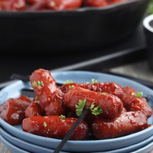 Smoked BBQ Smokies served on a small blue plate with a black toothpick for easy eating.